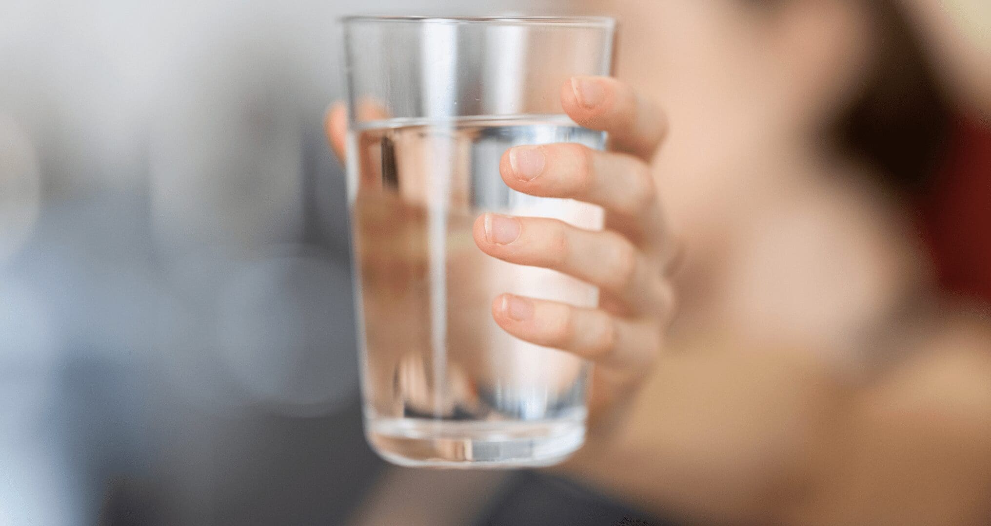 A person holding a glass of water