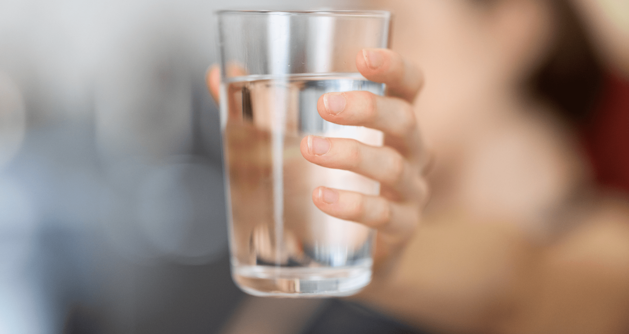A person holding a glass of water