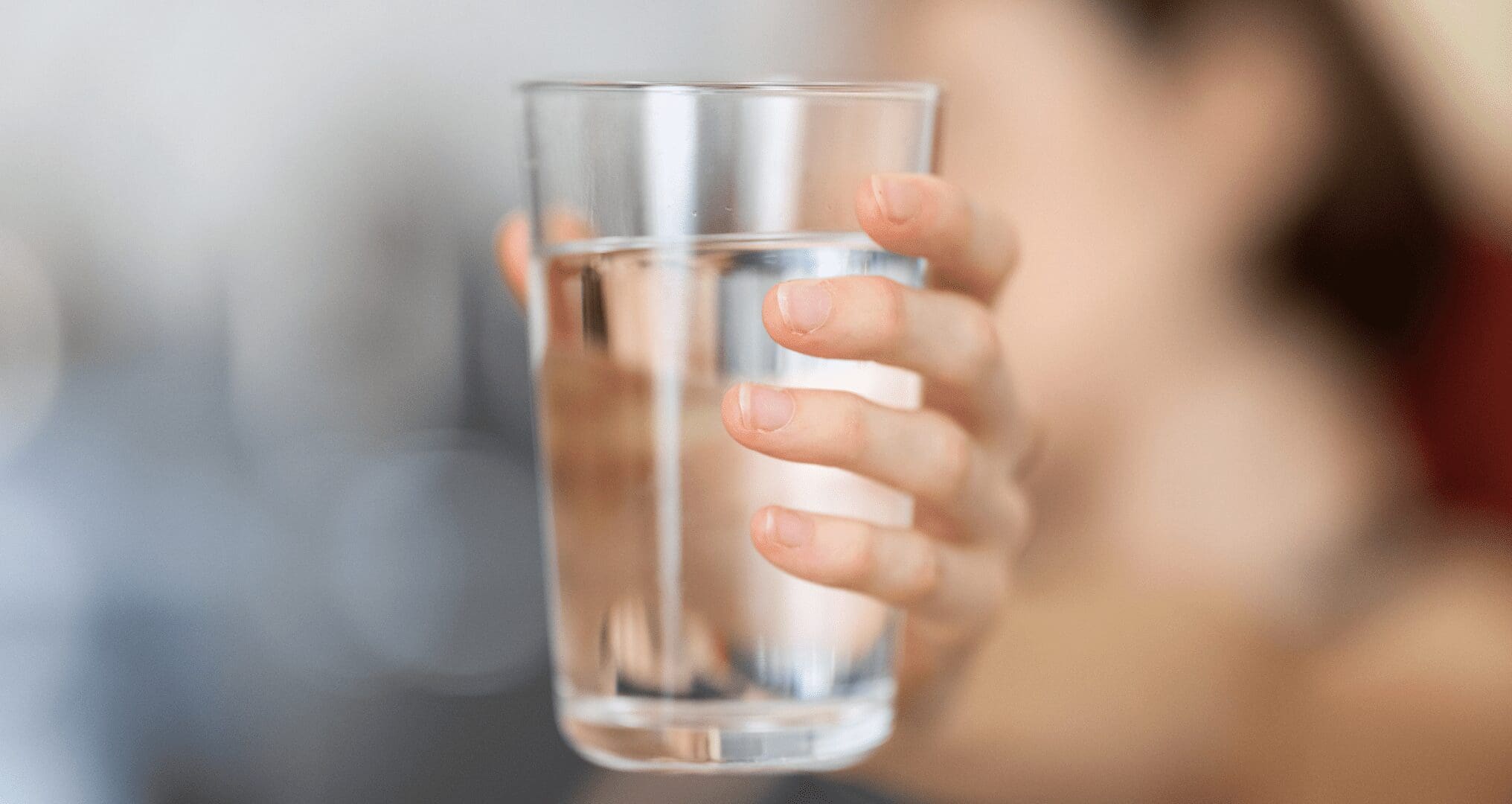 A woman holding a glass of water