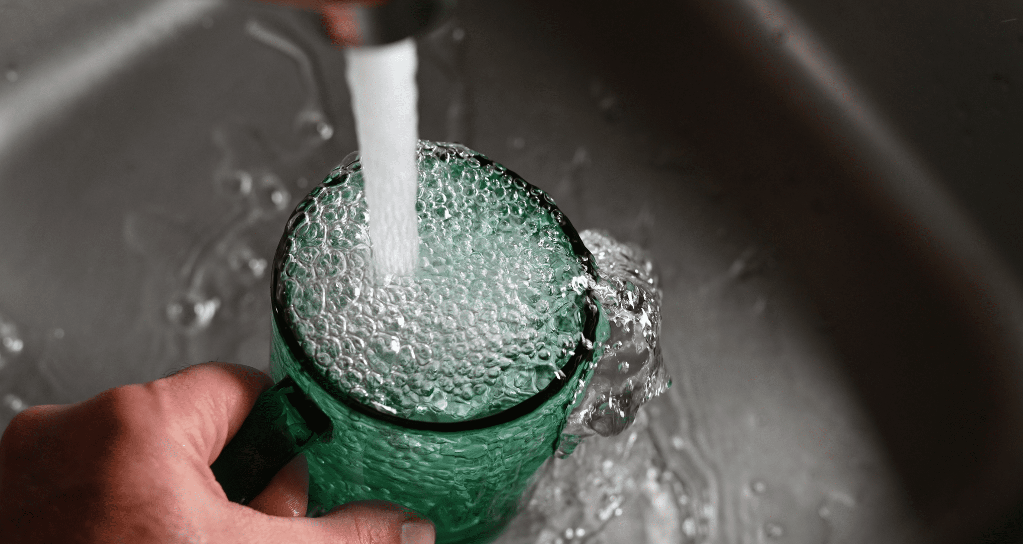 A person getting tap water from a home smart faucet A person getting tap water from a home smart faucet