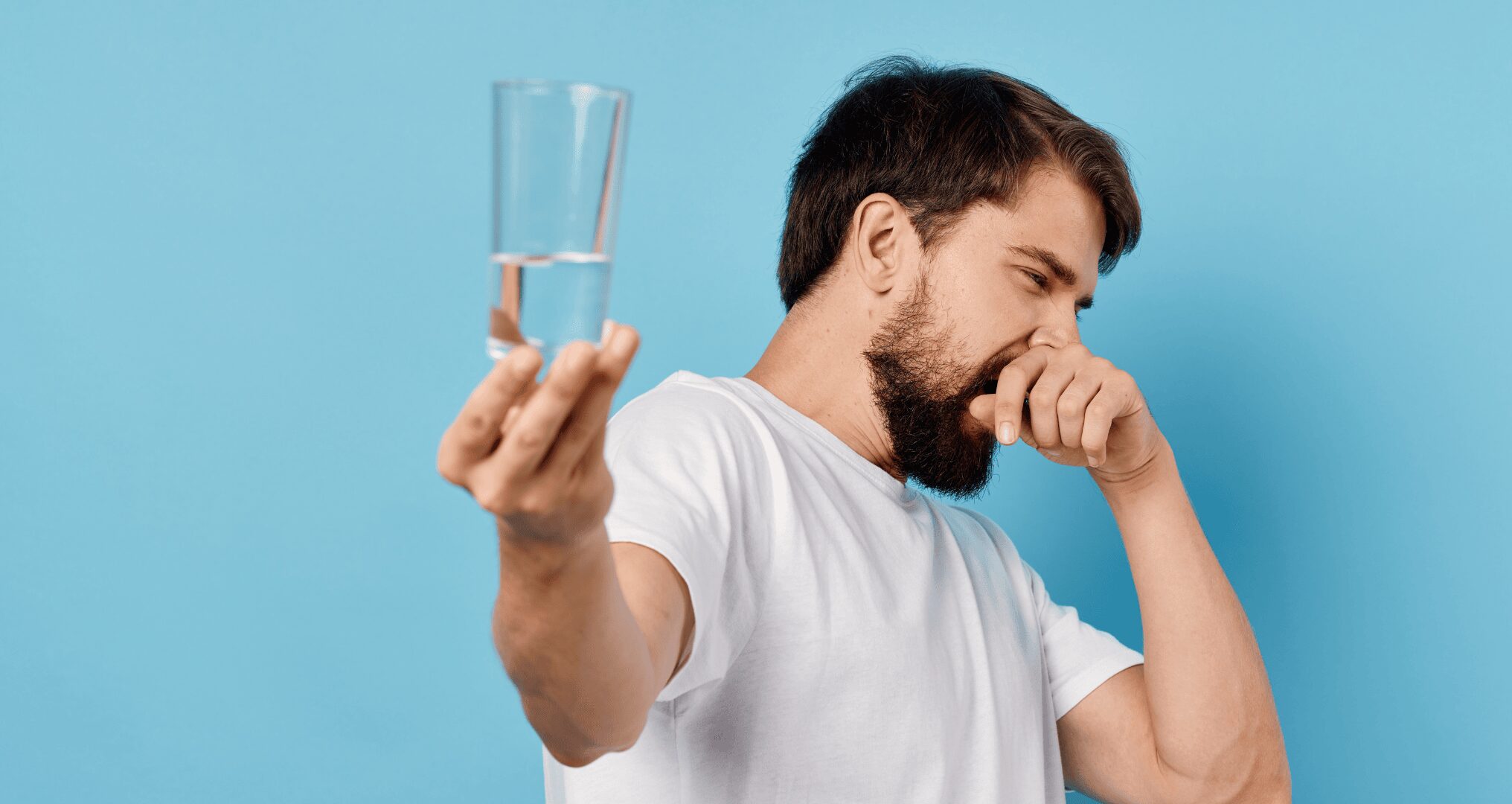 Why Southern Texas Water Smells Funny man holding stinky glass of water out away from himself