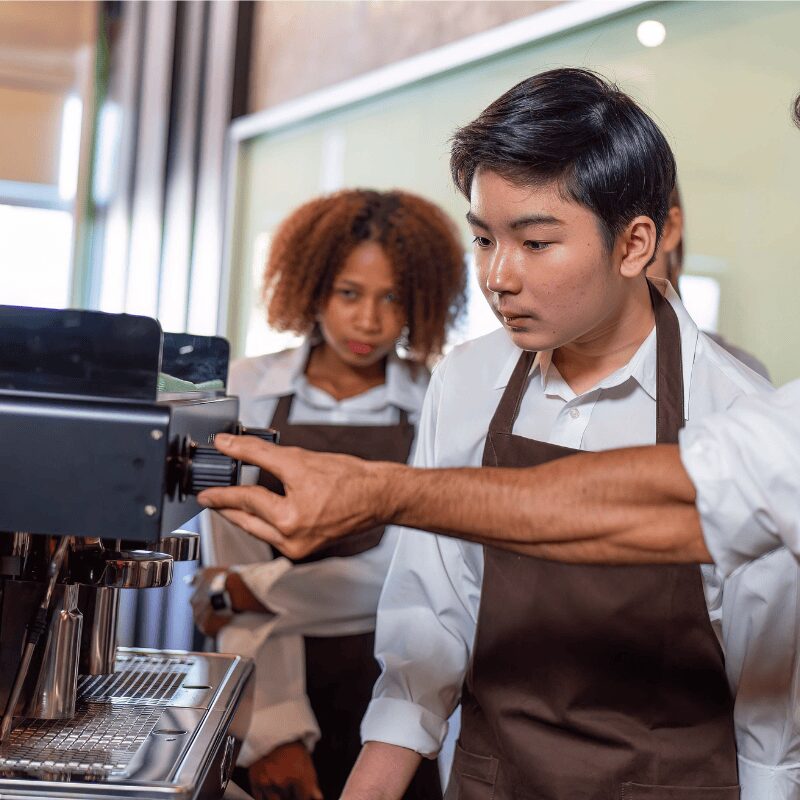 group of baristas troubleshooting on machine