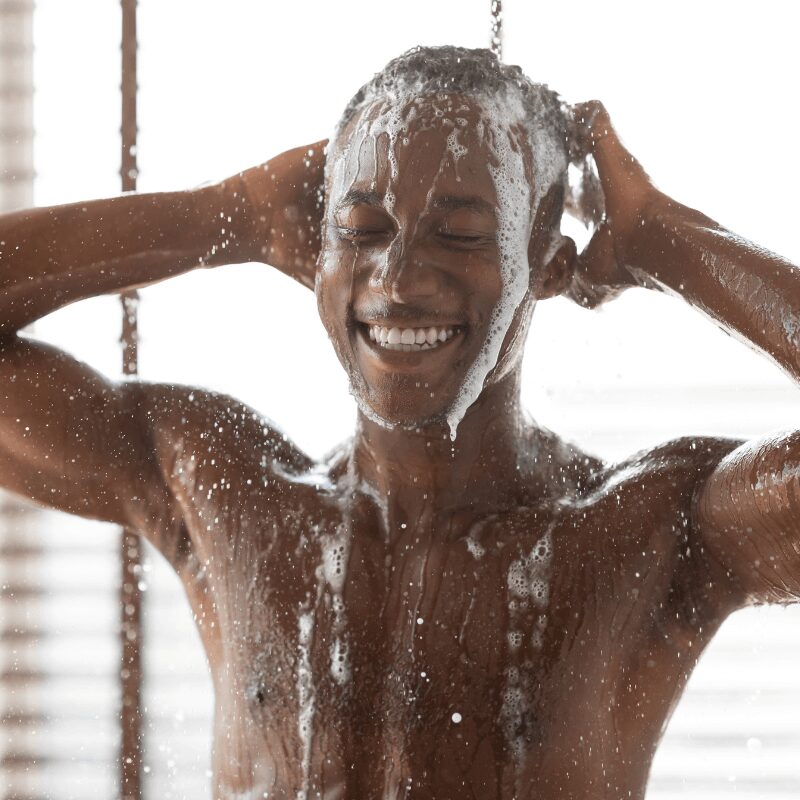 happy-african-guy-washing-head-taking-shower black man washing head in shower