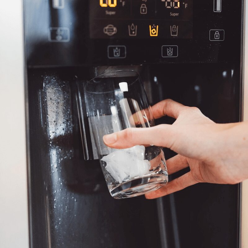 unrecognizable-woman-hand-holding-a-glass-getting woman holding glass getting ice out of machine