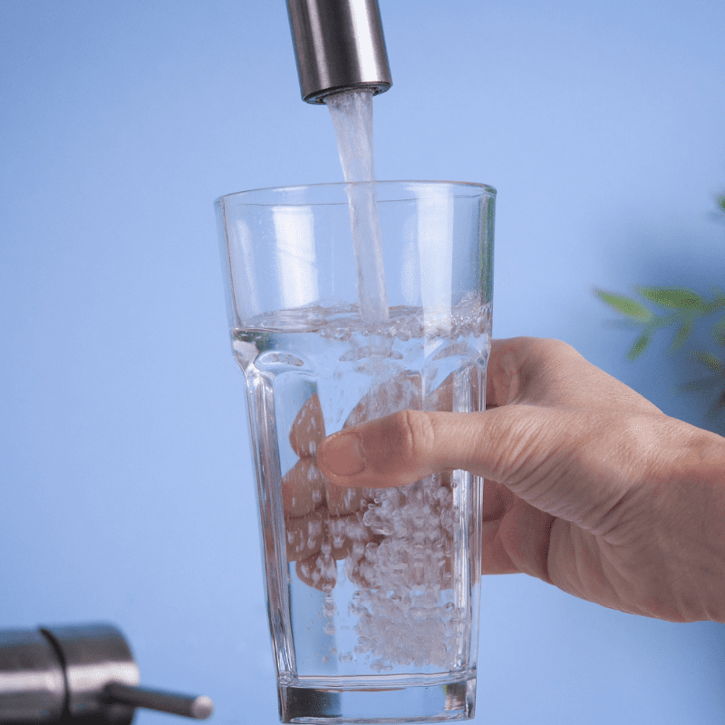 hand-holding-a-glass-and-filling-it-with-fresh water hand getting glass of water from tap