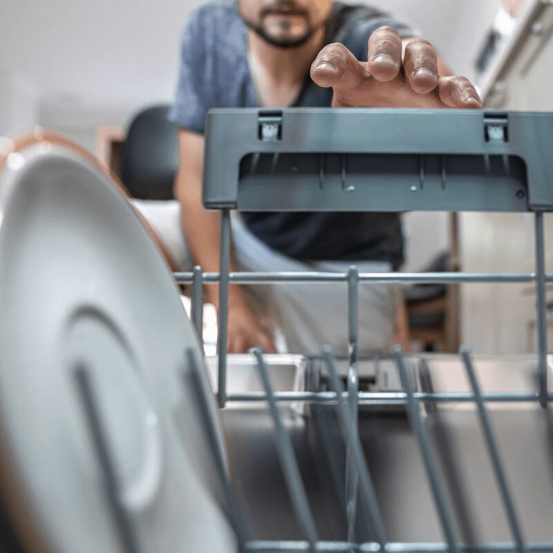 close-up of man reaching into dishwasher