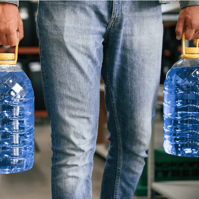close-up of man carrying bottled water jugs