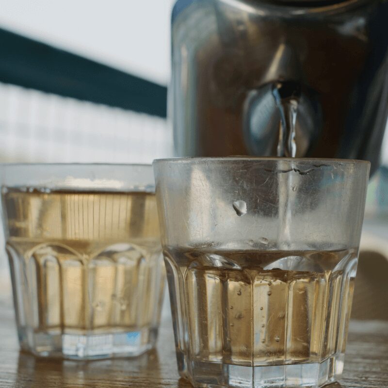 pouring brown water into glasses