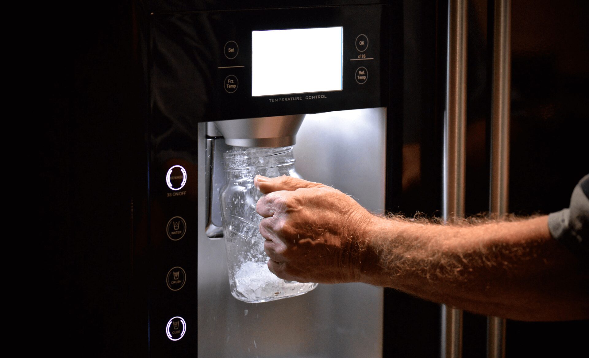front view of ice from ice machine melting against dark background