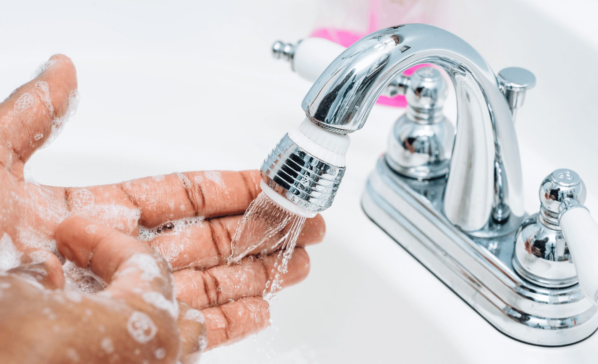 Close-up of man washing his hands in the bathroom