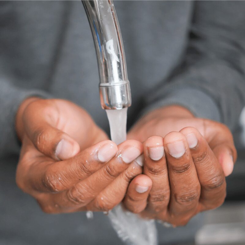 close up of young man washing his hands with soap and warm water