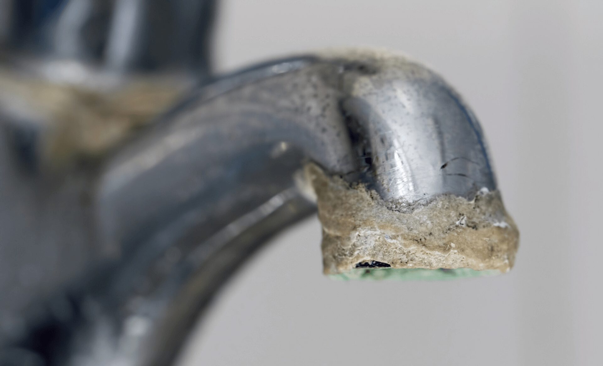 Up close picture of scale on a bathroom faucet.