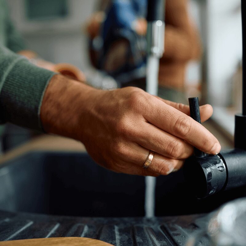 close-up-of-man-doing-the-dishes-in-the-kitchen Close-up of a man doing dishes in the sink