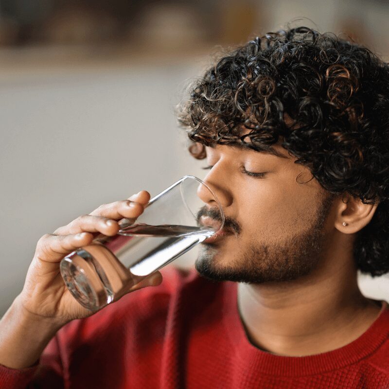 young Indiana man drinking water from a glass