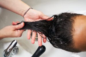 washing hair in the sink, applying a hair mask for smoothness