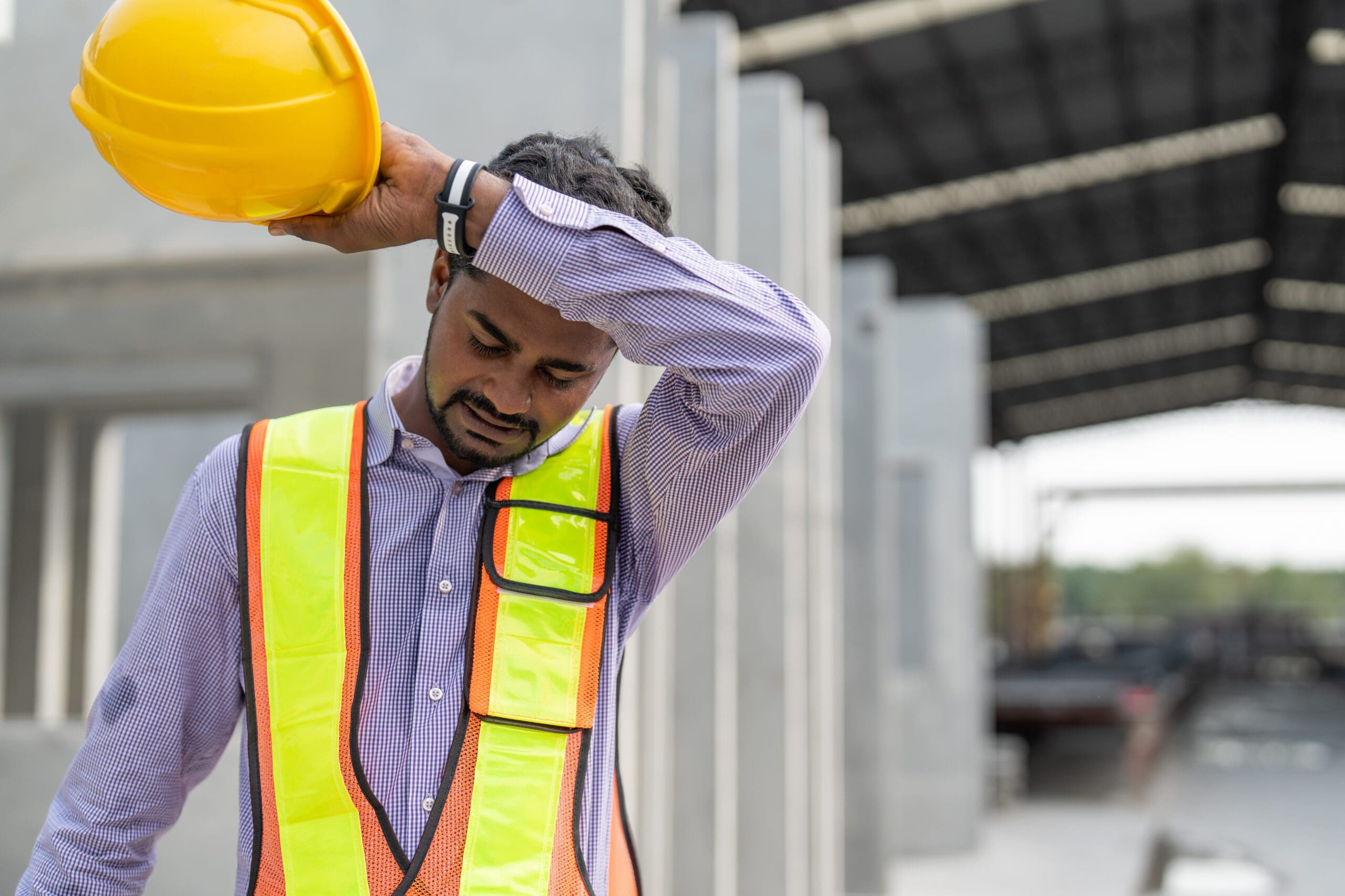 Construction worker, wiping sweat from his brow.