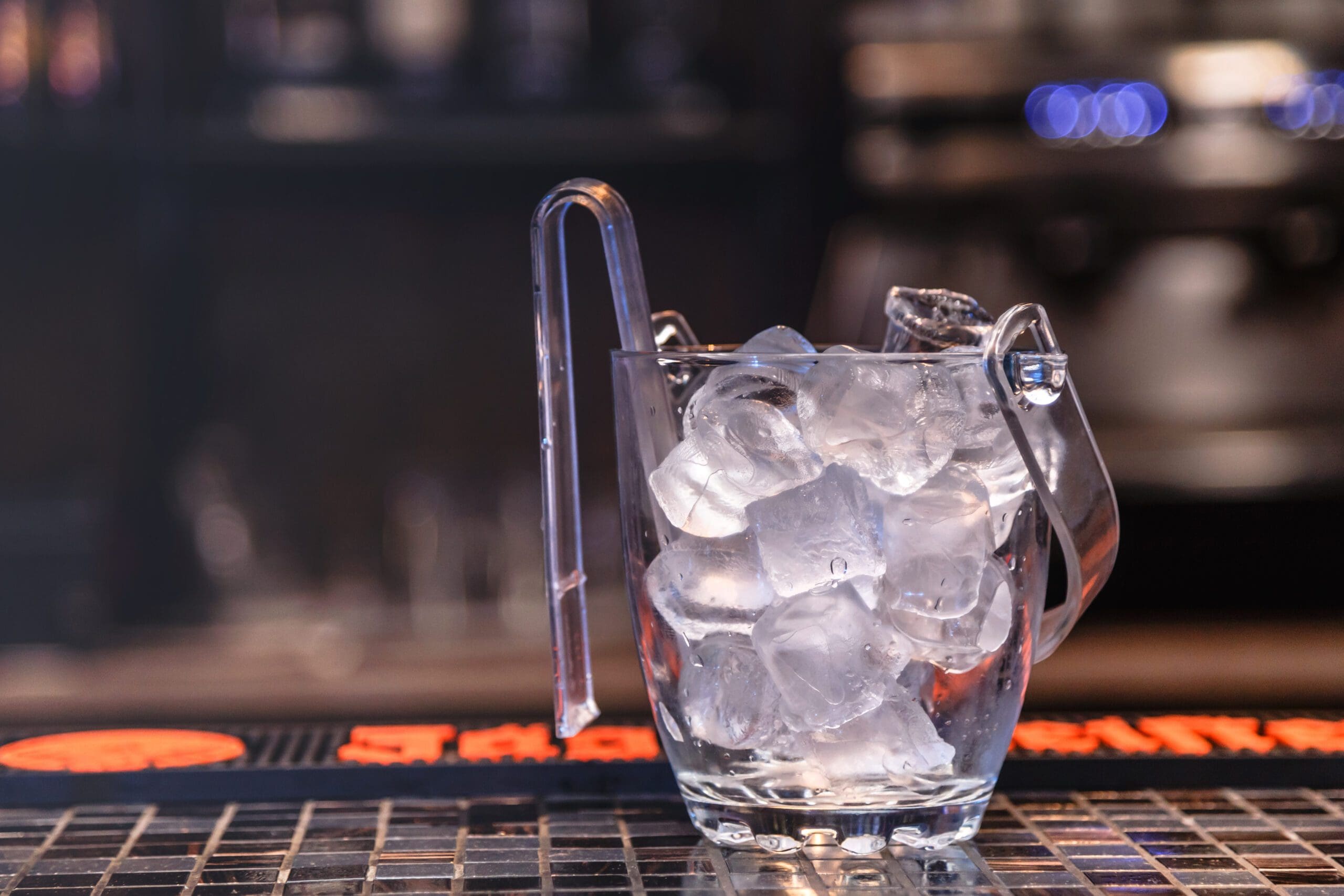 Bucket of ice sitting on a bar top