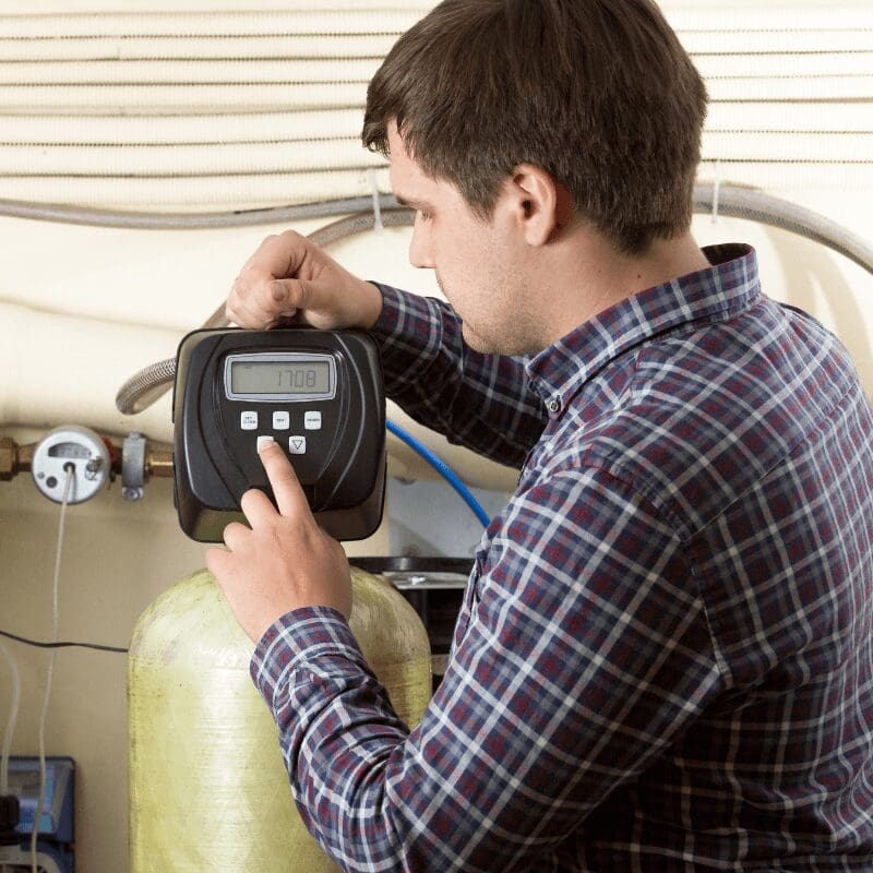 engineer-checking-pressure-meters-at-factory engineer checking on water pressure of a water softener setup