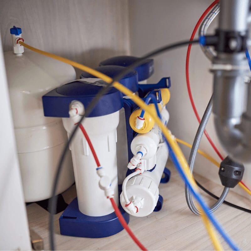 water-filtration-system-in-home-undersink-environment RO water filtration system under the kitchen sink